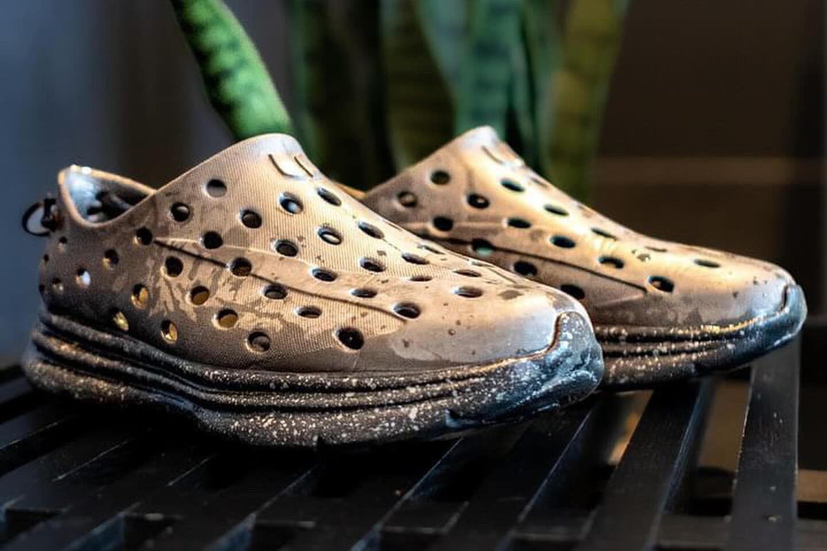 Front view of perforated shoes showcasing ventilation holes on a dark slatted surface