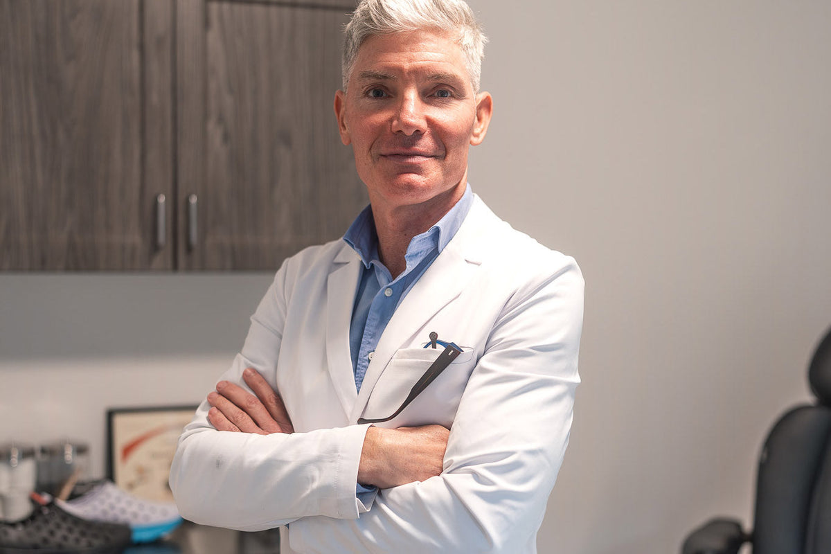 Medical professional standing with arms crossed in a clinical office