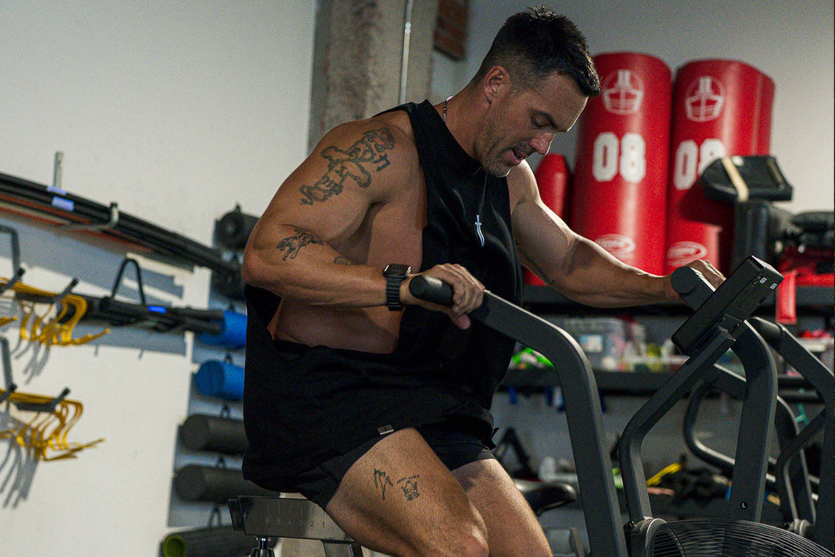 Man exercising on an air bike in a gym