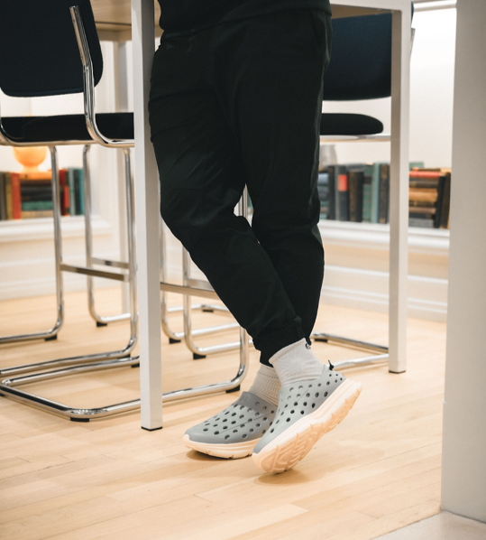 Closeup of a teacher at school wearing comfortable gray Kane Revive recovery shoes.