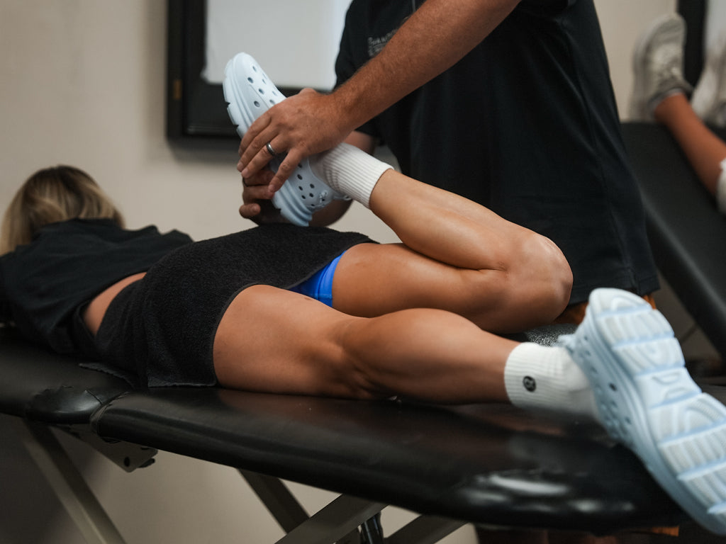 Person receiving knee therapy while lying on a treatment table