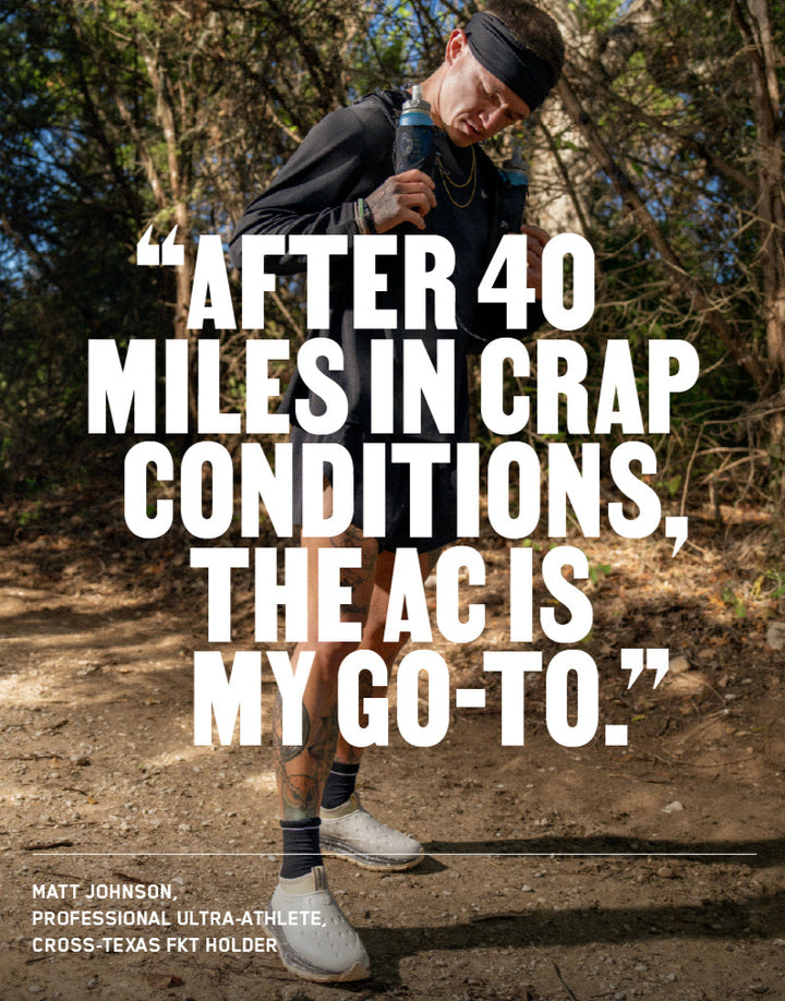 Athlete runs on a wooded trail wearing gray recovery shoes; “After 40 miles in crap conditions, the AC is my go-to”