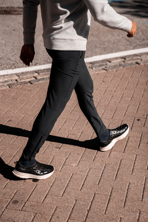 Closeup of a Cashier's shoes. He is walking to work wearing stylish Black Kane Revive recovery shoes. These shoes are supportive and comfortable, which are perfect for standing all day at a cash register.