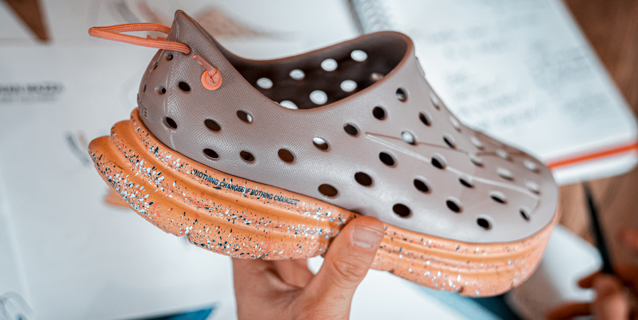 Close-up view of Kane Revive shoes being held by a hand. Developing the latest style in active recovery footwear.