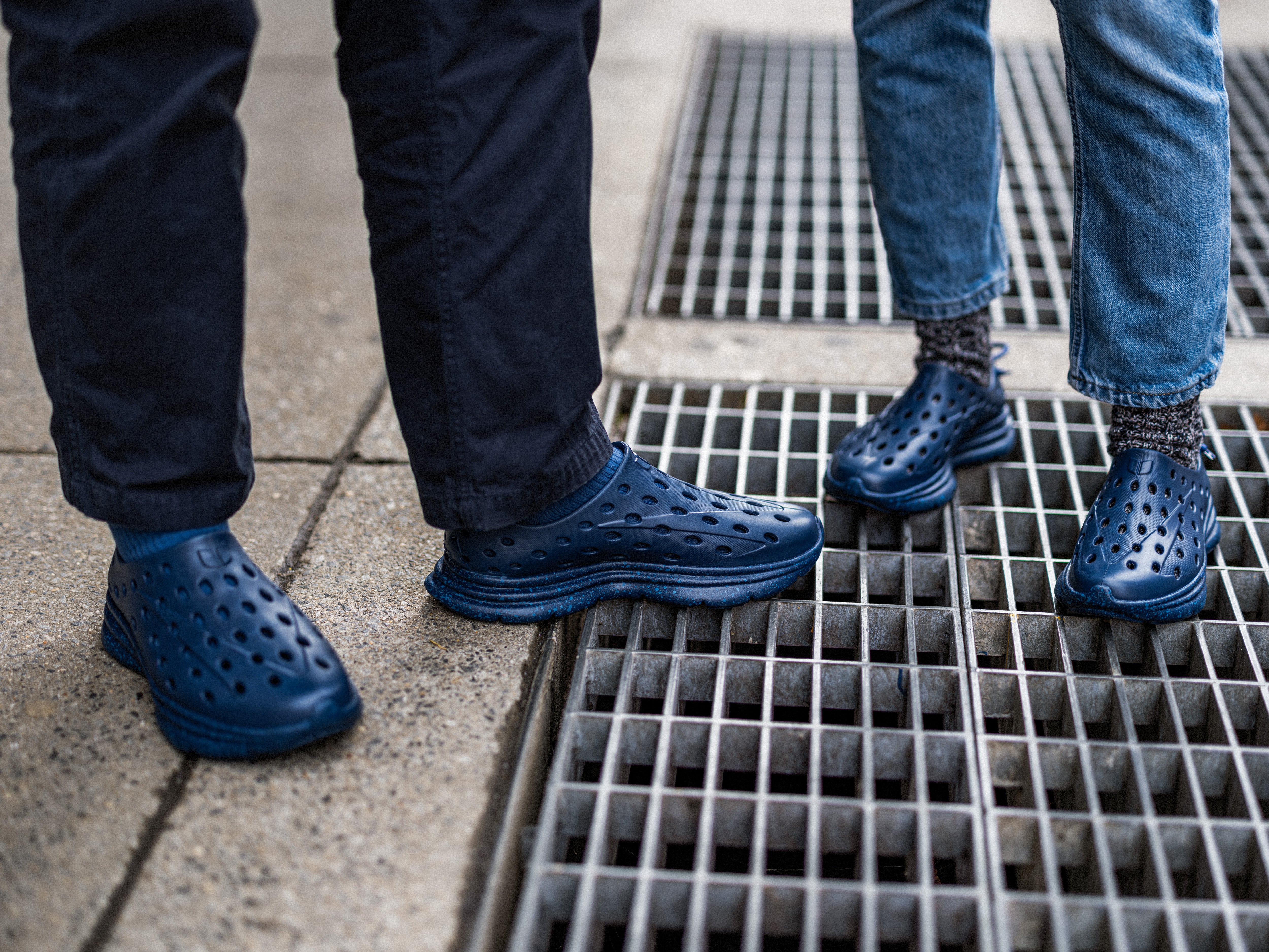 Two people wearing Navy Kane Revive recovery shoes, standing on the street. Zoomed in on their stylish footwear.